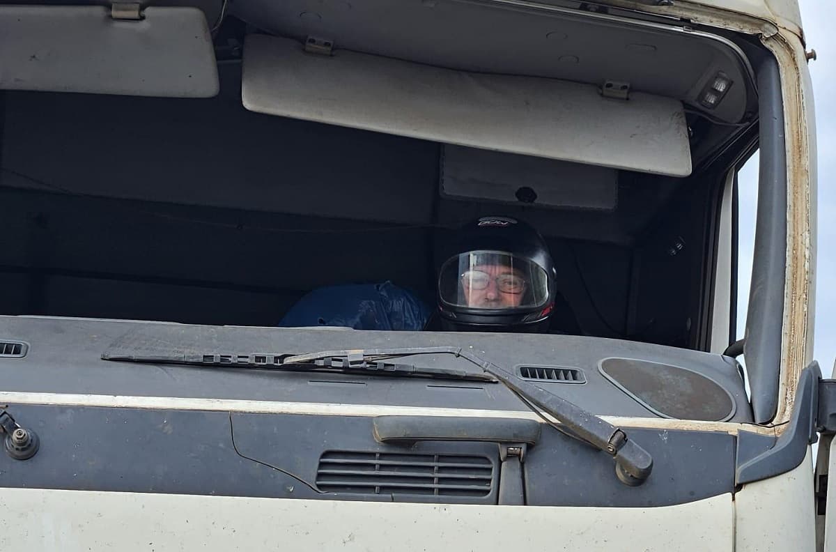 Caminhoneiro usa capacete para viajar com veículo sem para-brisa